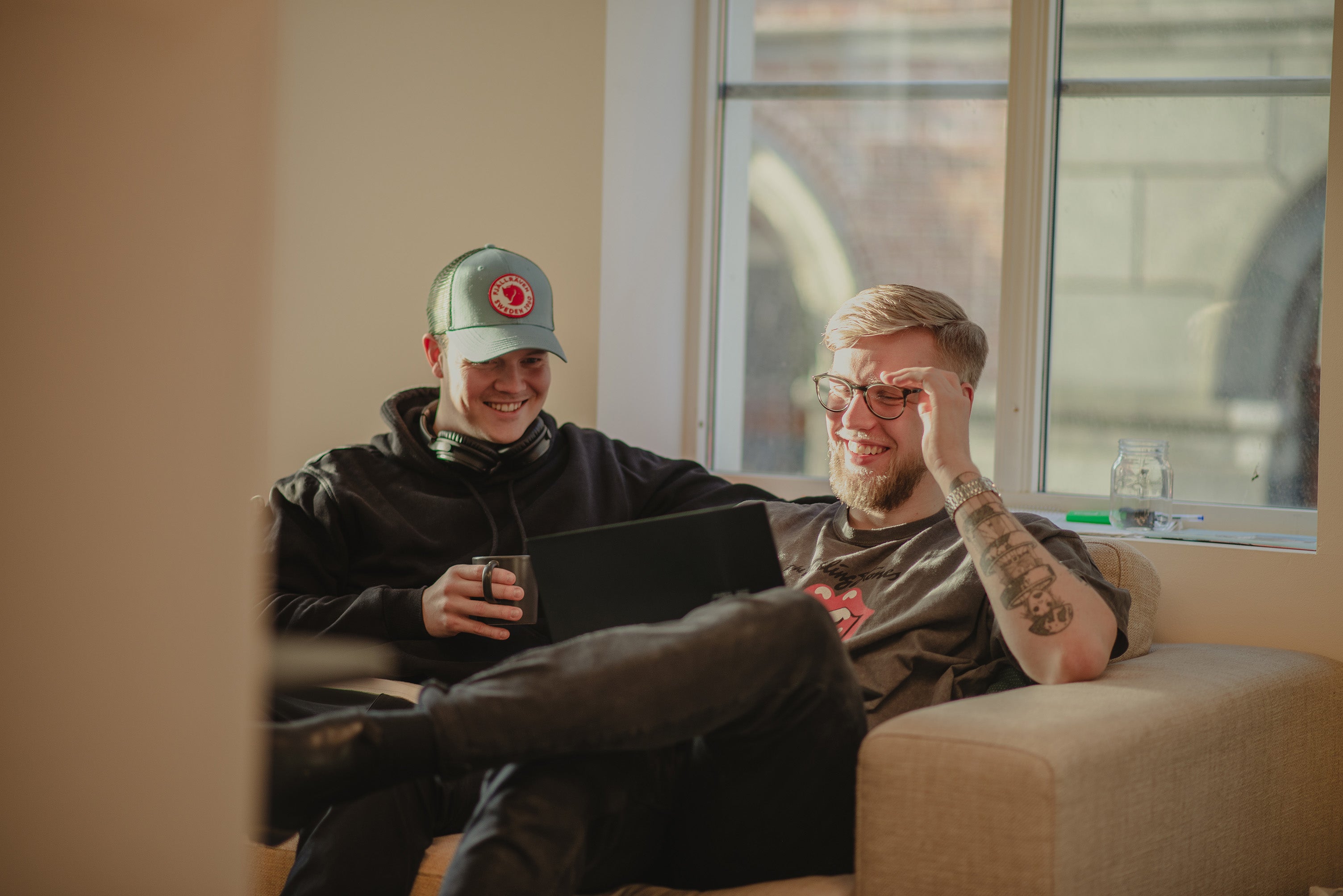 To menn sitter i en sofa og jobber freelance på co-work stedet Bergen Works