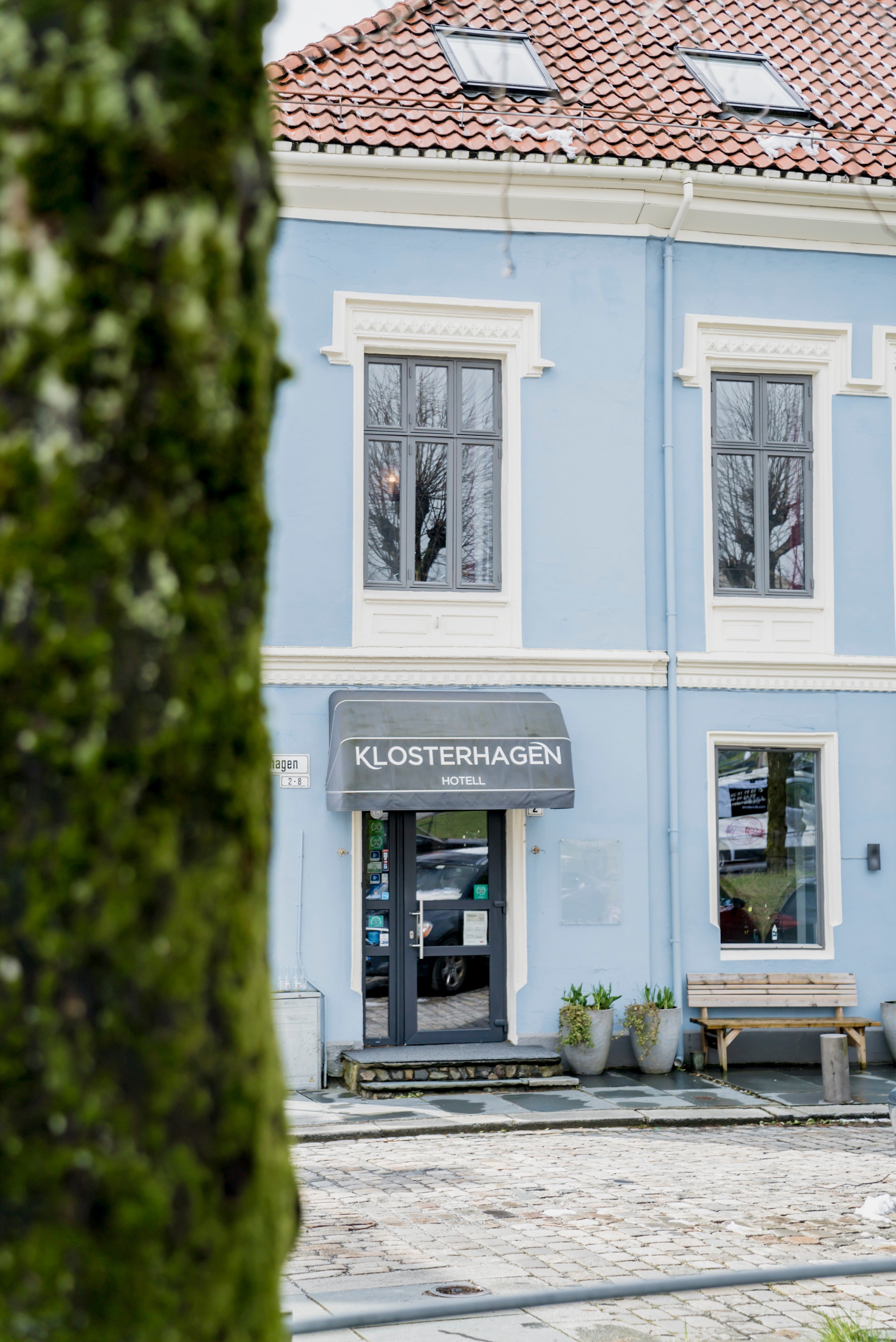 Blått bygg med inngang til Klosterhagen hotell