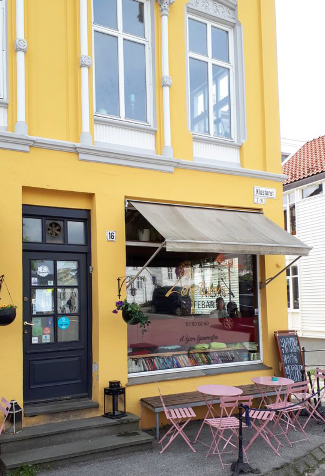 Gult bygg med inngangog uteservering  til Løvetann Kafé bistro i Bergen 